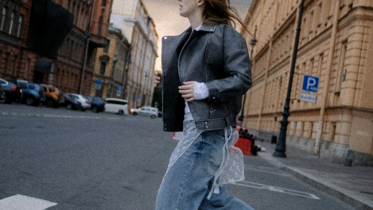 Blue jeans and boots crossing a road