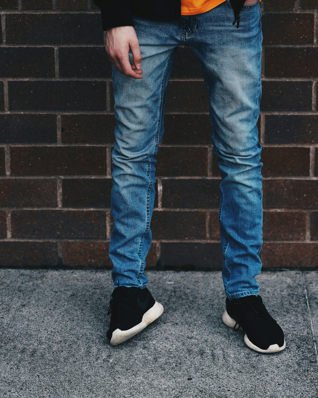 Slim jeans in rinse worn against a brick wall