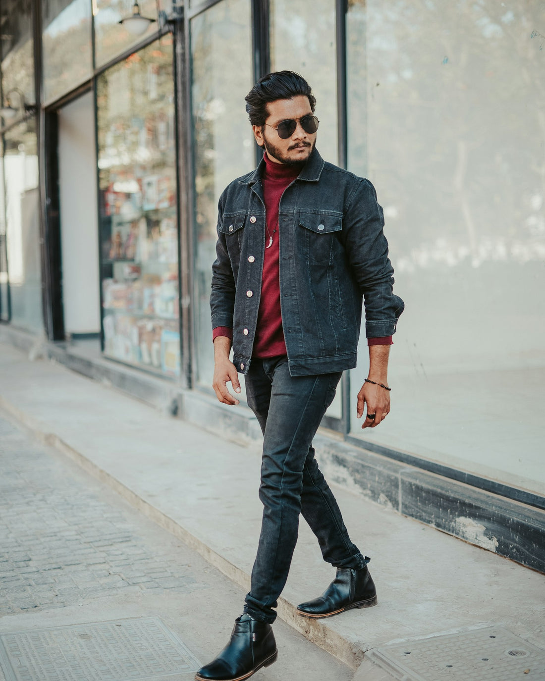 Washed black jeans worn walking along a shopfront
